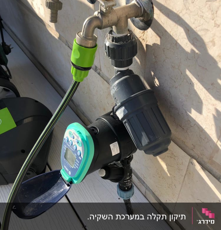 ברז מים עם טיימר השקיה מחובר לצינור ירוק
